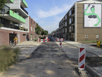 907849 Gezicht in de Troelstralaan te Utrecht, die heringericht en geasfalteerd wordt, met links de nieuwbouwwoningen ...